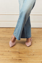 Scarlett Chase Belle Ballet Flat in Red Boucle with an adjustable Mary-Jane strap | Worn by a model standing in jeans with legs crossed on a wooden floor