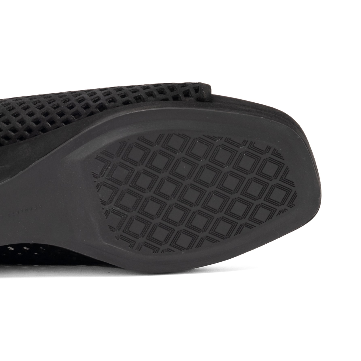 Scarlett Chase Chelsea Wedge Sandal with a perforated leather upper and adjustable back strap | Close-up of the black textured sole and mesh upper of sandal on a white background.