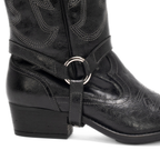 Scarlett Chase black leather Fiona cowboy bootie with decorative stitching and a side zipper and interchangeable knee-high gaiter with decorative sticking and clip-on straps| Detail of strap and lower part of knee-high gaiter attached to bootie on white background