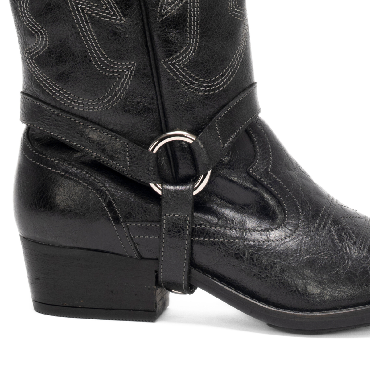Scarlett Chase black leather Fiona cowboy bootie with decorative stitching and a side zipper and interchangeable knee-high gaiter with decorative sticking and clip-on straps| Detail of strap and lower part of knee-high gaiter attached to bootie on white background