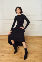 Scarlett Chase ankle stretch black suede Portia 75 bootie with a block heel |3/4 view on model with long black dress on wooden floor and white background