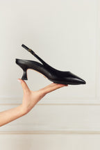 Scarlett Chase black napa leather Renee 55 Slingback with a stable, sculpted heel and an adjustable backstrap buckle | Profile view held in hand with white background