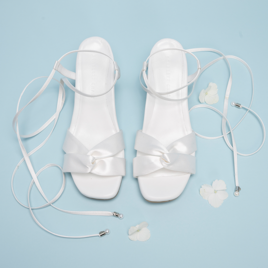 Scarlett Chase Cali 45 white satin dress sandal with wrap-around ties and a gathered front | Overhead view on blue background