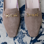 Scarlett Chase Weston Mule in Taupe Suede with floral lining and an SC gold accessory | Overhead 3/4 view on carpet background