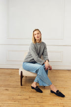 Scarlett Chase Weston Mule in Navy Suede and an SC gold accessory | Lifestyle shot in jeans on feet with wood floor background