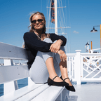 Scarlett Chase Belle Ballet Flat in Black Suede with an adjustable Mary-Jane strap | Worn by a woman sitting on a white bench on a pier