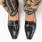 Scarlett Chase black embossed patent leather croc Chase loafer with gunmetal SC accessory | Overhead view on feet with patterned pants on white background