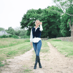 Scarlett Chase knee-high deep ocean stretch italian suede Clara 55 boot with a block heel | On model with legs crossed  in country background on dirt full length view front view 