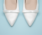 Scarlett Chase Gloria 55 White Satin Pump with a rounded upper, minimalist satin bow, and a sculpted heel | Overhead 3/4 view on light blue background 