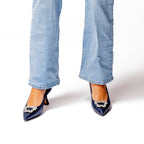 Scarlett Chase Poseidon metallic Grayson 55 Metallic Dress Pump with a rounded upper, sculpted heel, and a rhinestone toe accessory | Front view on feet with blue jeans right foot is 3/4 view on white background