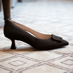 Scarlett Chase chocolate suede Greta 55 Pump with a rounded upper, sculpted heel, and chocolate toe accessory | Profile on cream and brown carpet in room