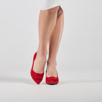 Scarlett Chase Rouge suede Greta 55 Pump with a rounded upper, sculpted heel, and red toe accessory | Pair On feet straight on with right shoe heel off ground and on toe on white background