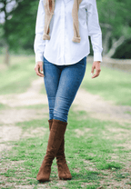Scarlett Chase knee-high stretch chocolate suede Lola 75 boot with a block heel | On model on grass with legs crossed front view outside 