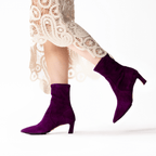 Scarlett Chase ankle stretch wine suede Maya 55 bootie with a block heel  | On model walking side view white lace long dress back shoe in air on white background