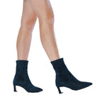 Scarlett Chase ankle stretch navy suede Maya 55 bootie with a block heel  | On model walking bare legs front foot on heel toe in air on white background