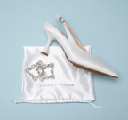 Scarlett Chase White Rory 75 Slingback with a stable, sculpted heel and an adjustable backstrap buckle and SC accessory | Profile on light blue background