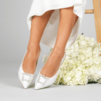 Scarlett Chase White Rory 75 Slingback with a stable, sculpted heel and an adjustable backstrap buckle with SC square accessory| Lifestyle shot on grey background