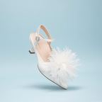 Scarlett Chase Rose 55 Pump with a rounded upper, sculpted heel, and adjustable back strap with pearl buckle and floral accessory| profile on light blue background