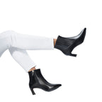 Scarlett Chase ankle zip italian black napa and calf leather Amelia 55  Bootie with a block heel and gore stretch | Side view on feet with white jeans in air on white background