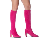 Scarlett Chase knee-high stretch bright pink suede Lola 75 boot with a block heel | on feet bare legs 3/4 view of right and profile of left staggered on white background