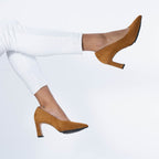 Scarlett Chase Scarlett 75 Pump Camel Suede with a V-cut upper and block heel | On foot of a model kicking feet up on a white background